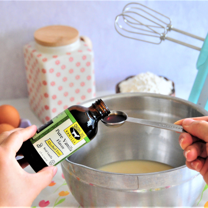 Someone pouring a teaspoon of Alcohol-Free Vanilla