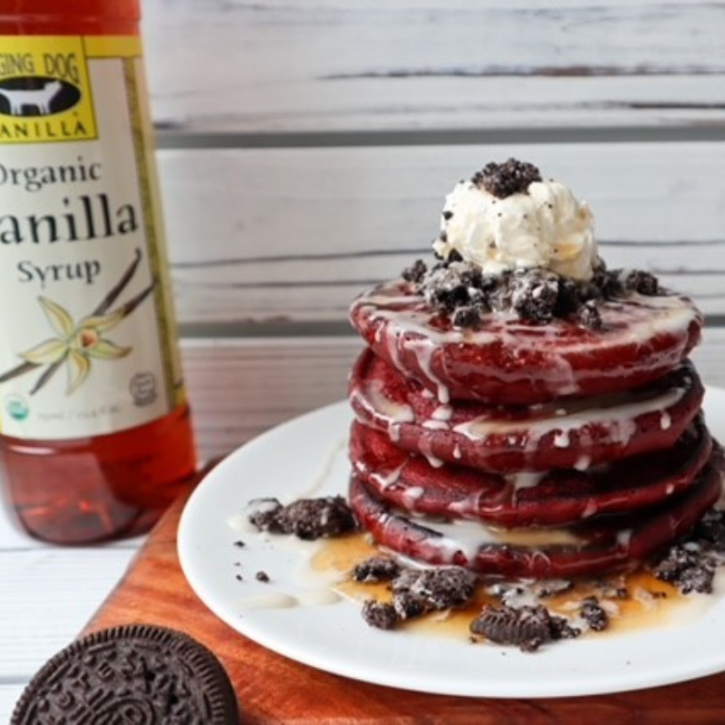 A stack of red velvet pancakes with gluten-free oreos and organic vanilla syrup