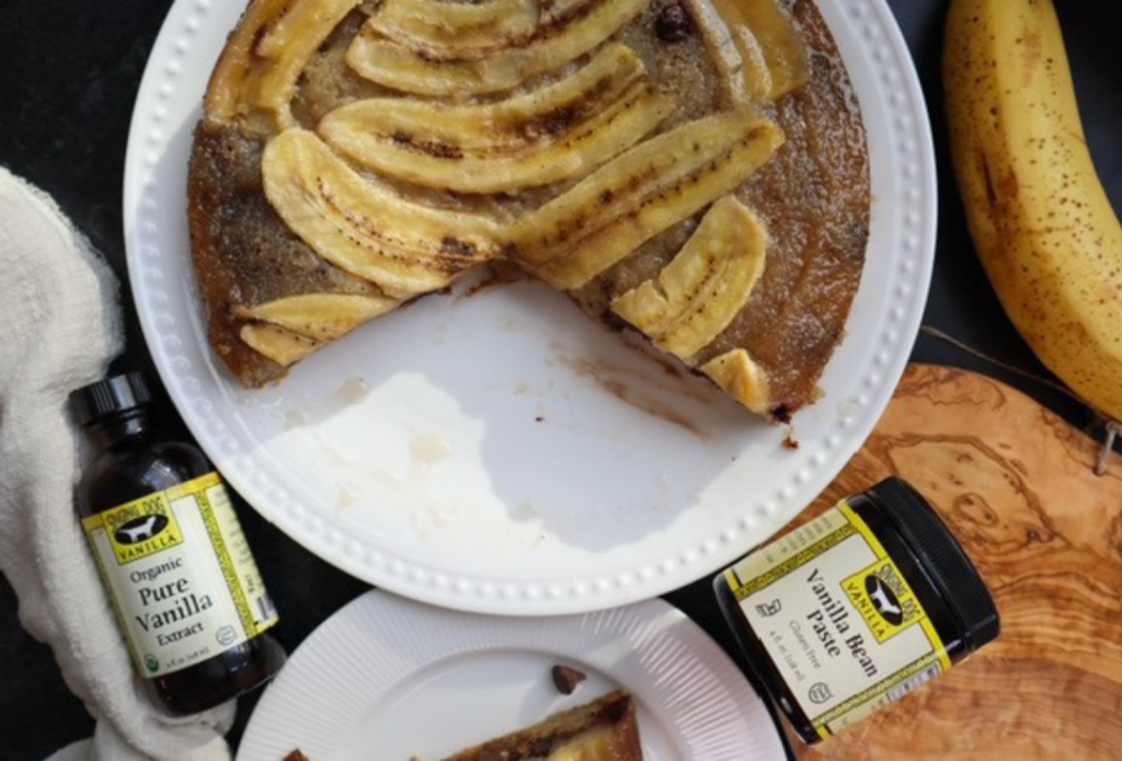 Banana Upside Down Cake on a plate with vanilla, cinnamon and banana